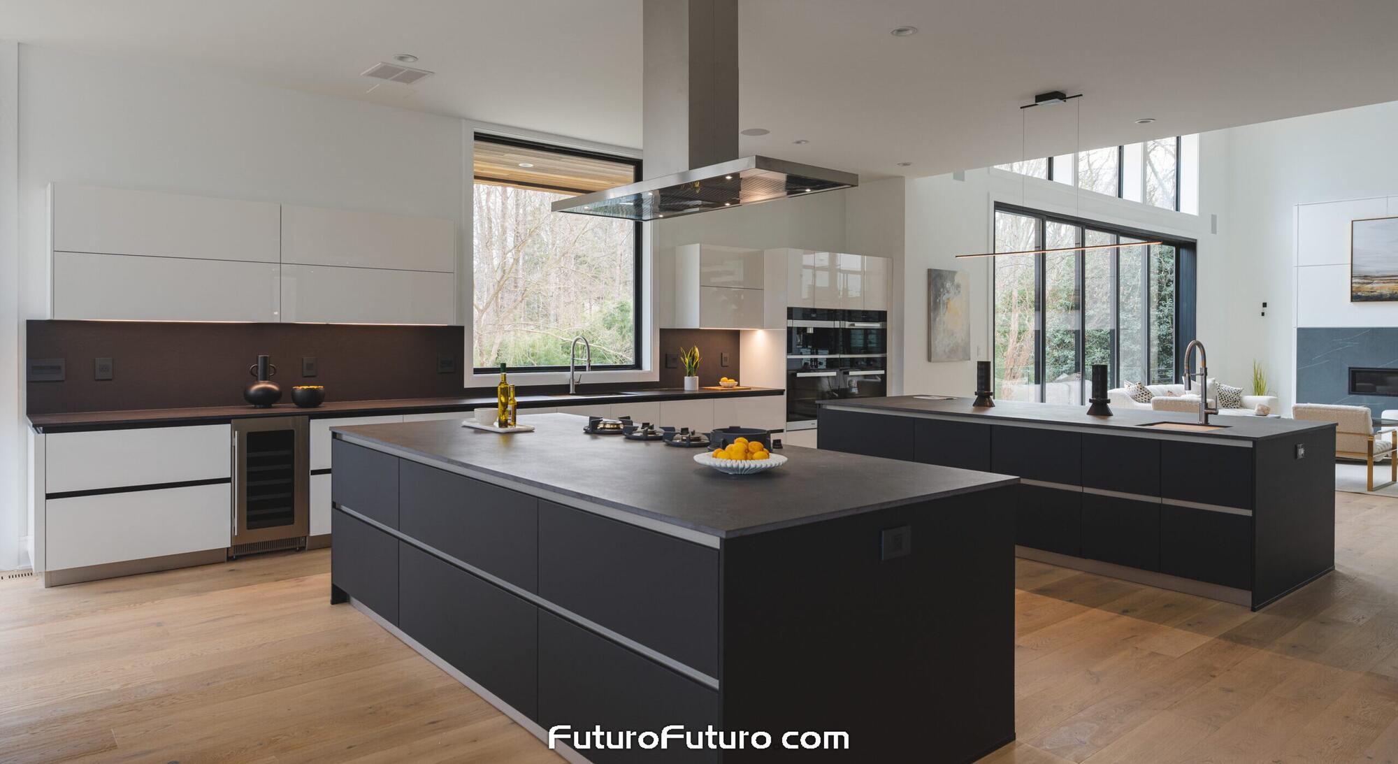 Stainless steel Futuro Futuro 60 inch Silvana island range hood over a black cooktop island in a bright McLean Virginia kitchen with twin black islands, white cabinets, and floor-to-ceiling glass walls.